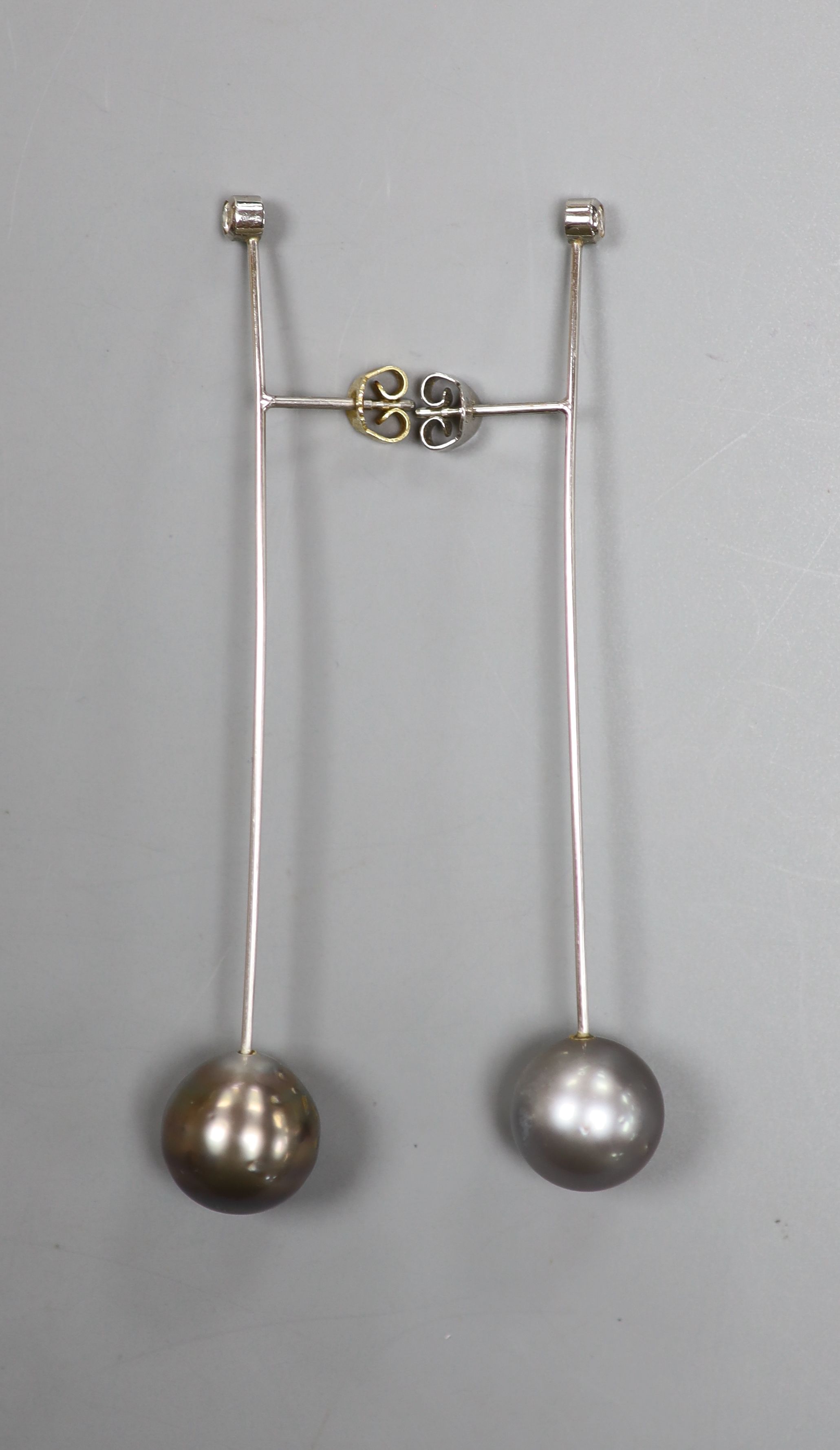 A pair of white metal, cultured Tahitian pearl and diamond set bar earrings